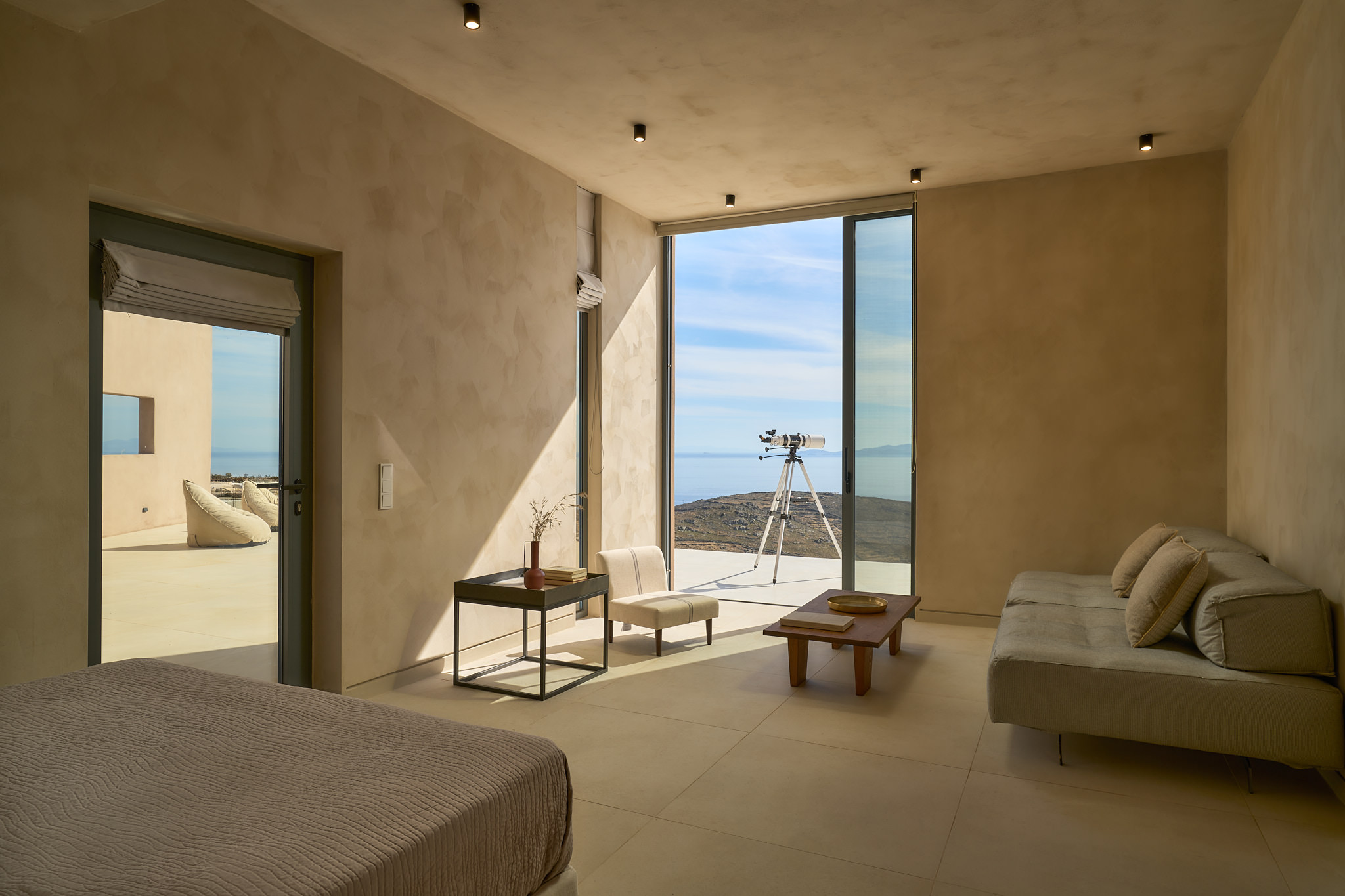 The "4th suite" lounge area, features a cozy lounge area and a queen size bed overlooking the Aegean Sea.